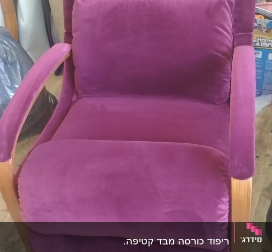 כורסה מרופדת בבד סגול עם ידיות עץ